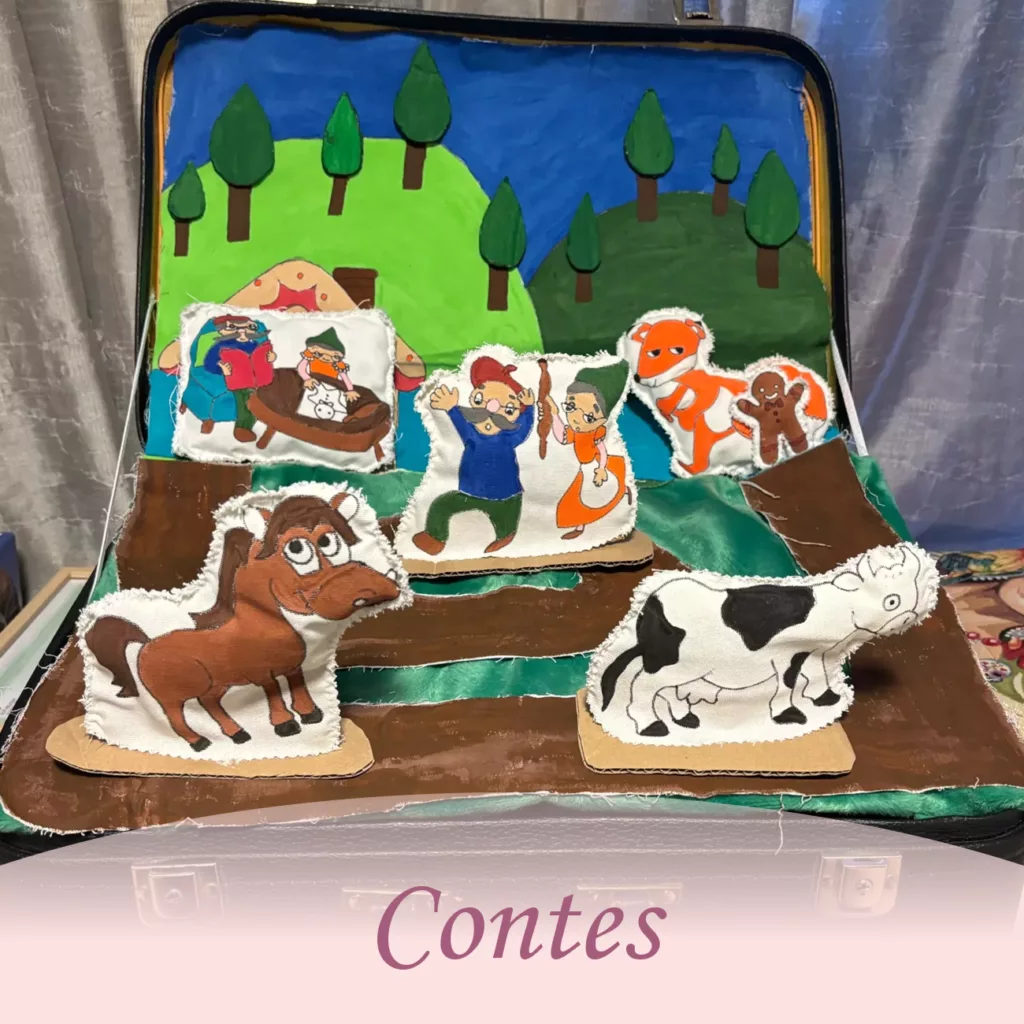 Décor de conte pour enfants avec figurines en tissu représentant des animaux de ferme et des personnages dans une valise